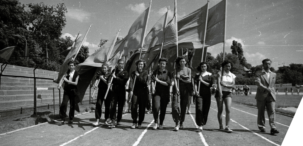 A group of people carrying flags on a racetrack